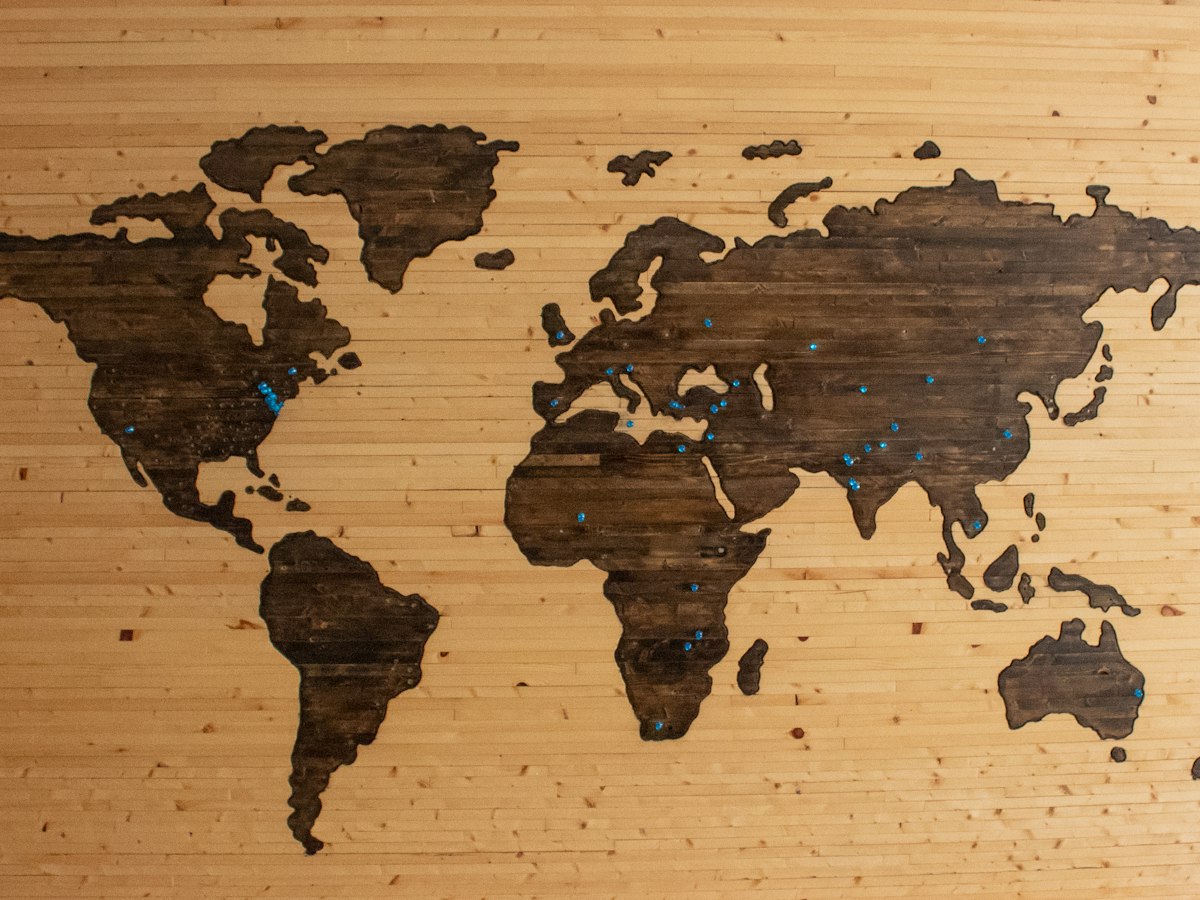 In Holz gearbeitete Weltkarte als Symbol für internationales Forderungsmanagement
