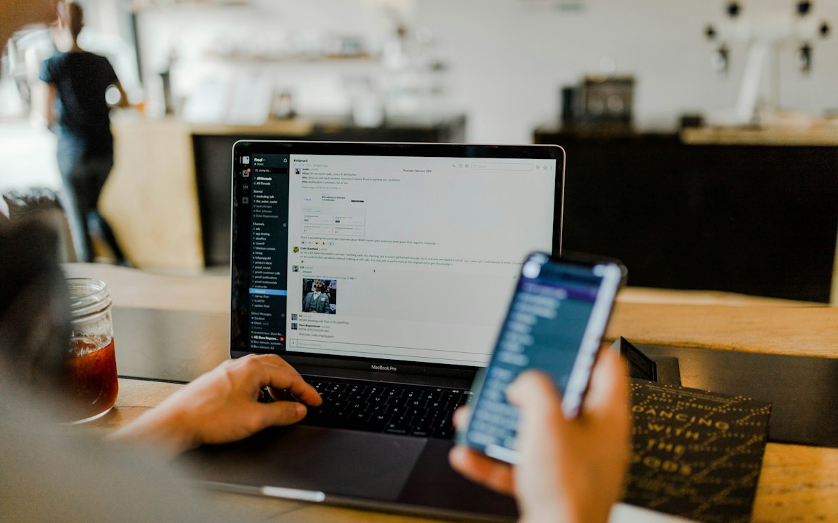 Freiberufler arbeitet in einem Café an Laptop und Smartphone