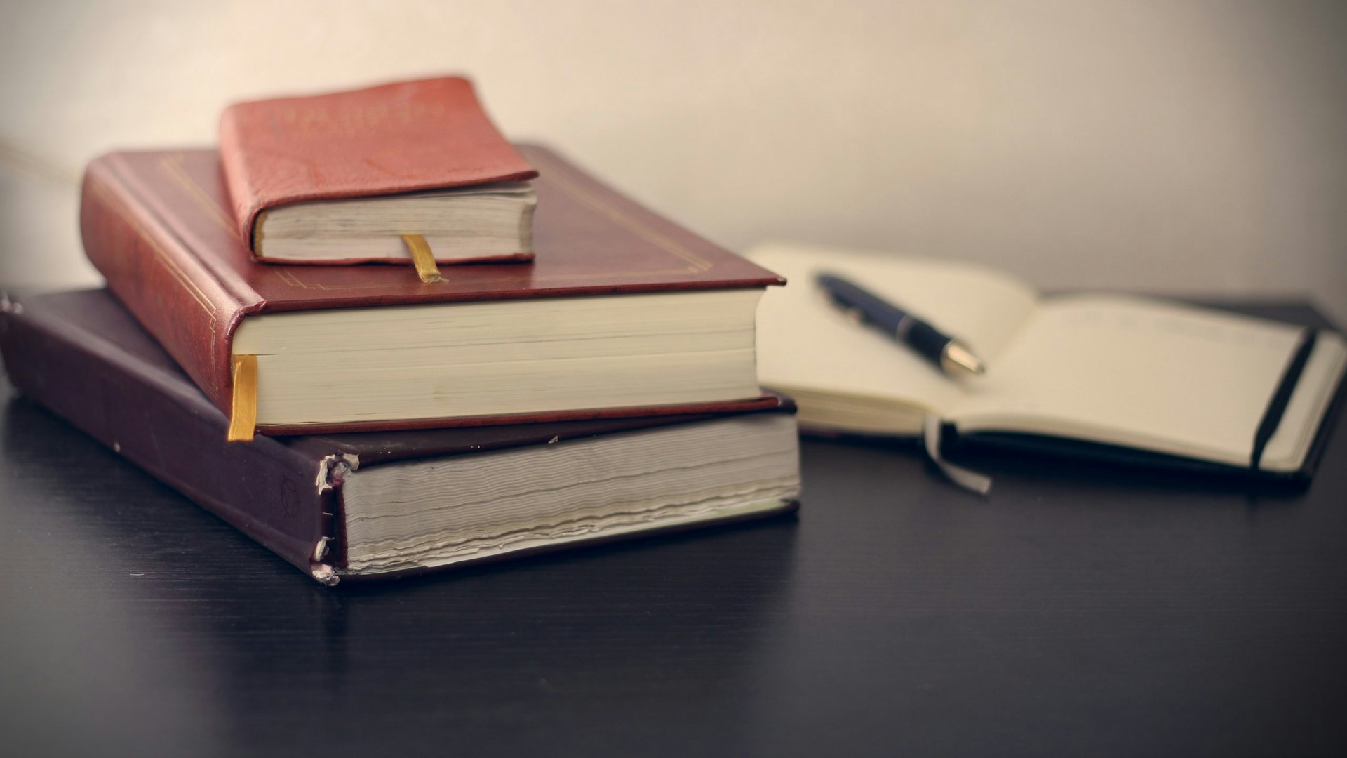 Gebundene Fachbücher mit Füllfederhalter auf einem Schreibtisch – Symbolbild für den Ratgeber Forderungsmanagement